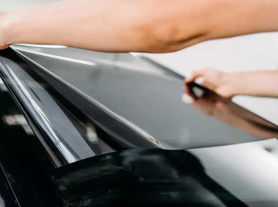 man applying 5 percent window tint on the rear windshield