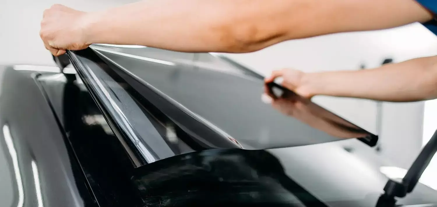 Window Tinting man applying 5 percent on the rear windshield